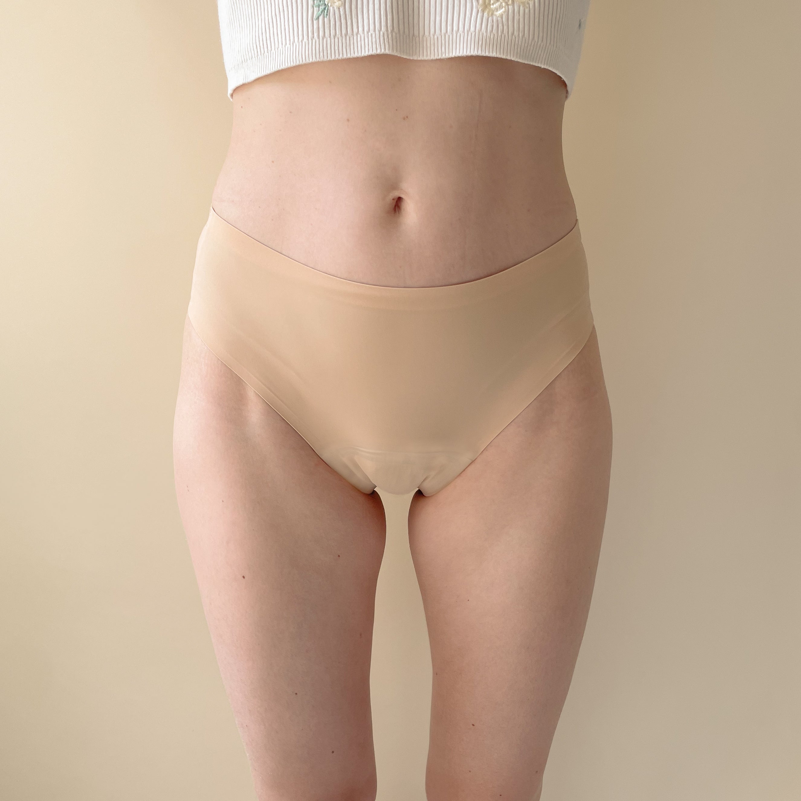dais seamless period underwear with cheeky cut in beige colour made of nylon shown on model from the front.